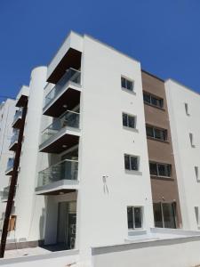 einen externen Blick auf ein weißes Apartmenthaus in der Unterkunft Egkomi Luxury Suites in Nikosia