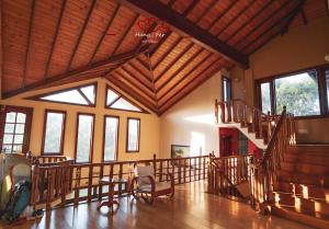 a large room with a wooden ceiling and stairs at 中国蒲公英民宿Dandelion Guest house Villa with Mount View in Kandy