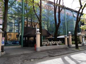 a glass building with the michelinamedo sign on it at Hotel Michelangelo in Forlì