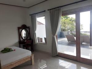 a bedroom with a bed and a sliding glass door at Galang Kangin Bungalows in Amed