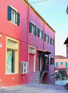 a red building with stairs in front of it at Darmani Spyros Apartments in Mantoúkion