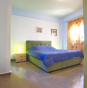 a bedroom with a bed with a blue comforter at Darmani Spyros Apartments in Mantoúkion