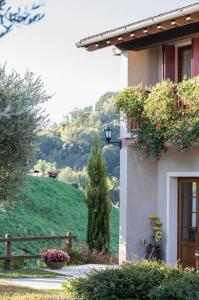 a house with a green hill in the background at Agriturismo al Capitello in Asolo
