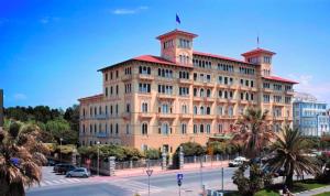 Un gran edificio con una bandera encima. en Appartamento Le Mimose, en Viareggio