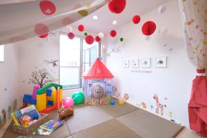 pokój dla dzieci z placem zabaw z domkiem dla zabawek w obiekcie Bremen House ~ブレーメンハウス~ w mieście Yomitan