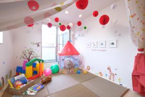 - une salle pour enfants avec une aire de jeux avec une maison de jouets dans l'établissement Bremen House ~ブレーメンハウス~, à Yomitan