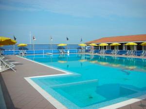 una gran piscina con sillas y sombrillas en Appartamento Le Mimose, en Viareggio