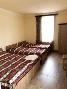 two beds in a room with a window at Zanger Hotel in Goris