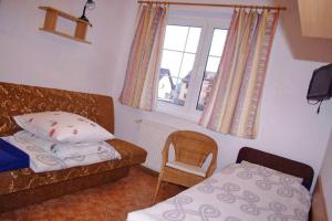 a bedroom with a bed and a chair and a window at Helena in Karwia