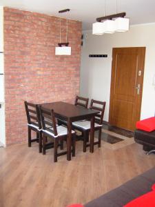 a dining room with a table and chairs and a brick wall at Los Reyes in Krynica Morska