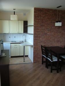 a kitchen with a table and a brick wall at Los Reyes in Krynica Morska