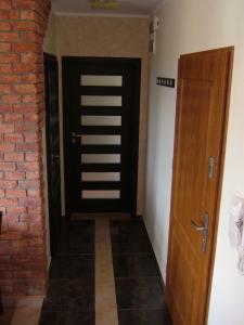 a hallway with a black door and a brick wall at Los Reyes in Krynica Morska
