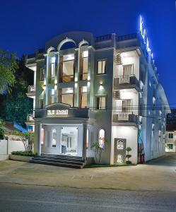 a large white building with a sign on it at K.C Hotel in Yangon