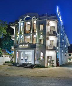 un grande edificio bianco con un cartello sopra di K.C Hotel a Yangon