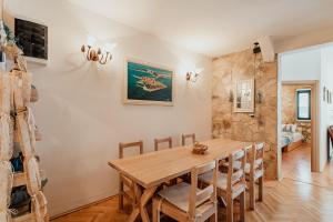 a dining room with a wooden table and chairs at Stone House Herceg Novi in Herceg-Novi