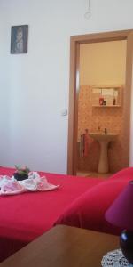 um quarto com uma cama vermelha e um lavatório em Apartments&Rooms Miro Sea view - near Beach em Sumartin