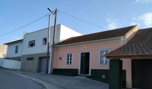 a street view of a pink and white house at Casa da Tia Dulce in Pataias