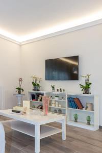 a white living room with a white table and a tv at La camelia bianca in Rome