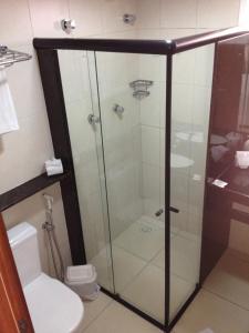 uma cabina de duche em vidro numa casa de banho com WC em Saint Patrick Praia Hotel em Maceió