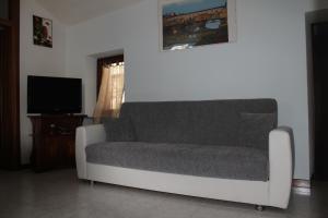 a living room with a couch and a tv at Appartamento Cielo in Costermano