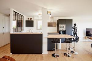 a kitchen with black and white cabinets and a counter at Jean Bart - proximité centre - 2 chambres 90 m2 avec jardin in Saint-Brieuc