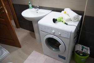 una lavatrice in un bagno accanto a un lavandino di Porto Frailis 2 a Tortolì