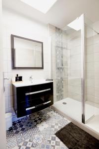a bathroom with a shower and a sink and a mirror at Jean Bart - proximité centre - 2 chambres 90 m2 avec jardin in Saint-Brieuc