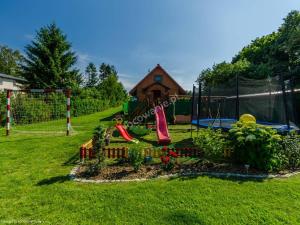 um quintal com um parque infantil com uma casa em Domki Niesiołowice em Niesiołowice