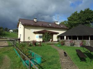 a building with a dog walking in front of it at Stajnia Grazyny Mikorowo 46 in Czarna Dąbrówka