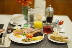a table with two plates of breakfast food on it at Dene House Guest House in Bowness-on-Windermere