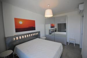 a bedroom with a white bed and a bedroom with a bathroom at Appartamenti porta mare in Otranto +37 photos