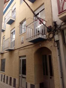 a building with a balcony on the side of it at Apartamentos das Avós- Wimari in Nazaré