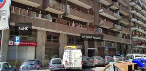 un estacionamiento con autos estacionados frente a un edificio en My Sweet Rooms, en Roma