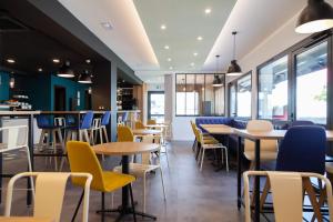a restaurant with tables and chairs and windows at Kyriad Niort-Espace MendesFrance in Niort