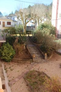 a set of stairs in a yard with trees and bushes at Superbe T2 3 étoiles à proximité des thermes et des pistes cyclables in Lamalou-les-Bains