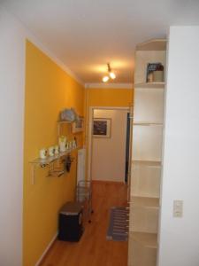 a room with a yellow wall and a shelf at Strandleben 1 in Grömitz