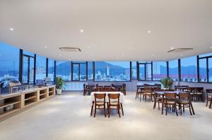 a dining room with tables and chairs and windows at For You Hotel in Nha Trang