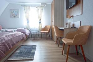 1 dormitorio con 1 cama, mesa y sillas en Hotel Zum Böhmegrund, en Bad Fallingbostel