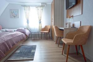 a bedroom with a bed and a table and chairs at Hotel Zum Böhmegrund in Bad Fallingbostel