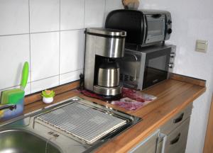 eine Küchentheke mit einer Spüle und einer Mikrowelle in der Unterkunft Ferienwohnung Sundhagen in Reinberg