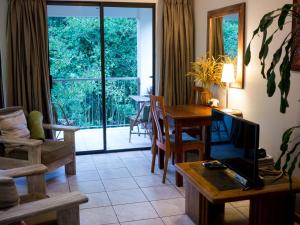 a living room with a television and a table with a tableablish at Africa's Eden Guesthouse in Pietermaritzburg
