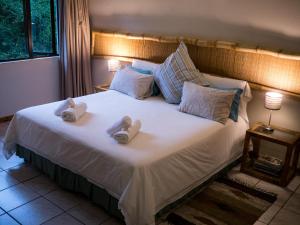 a bedroom with a large bed with towels on it at Africa's Eden Guesthouse in Pietermaritzburg