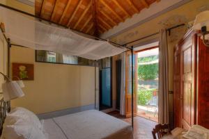 a bedroom with a canopy bed with a balcony at Le stanze del Casale - Maison in Portoferraio +10 photos