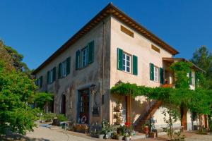 a building with green shutters on it at Le stanze del Casale - Maison in Portoferraio