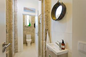 een badkamer met een wastafel, een toilet en een spiegel bij Luxurious Pink House and Parking in Porto +49 foto's