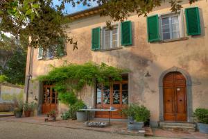 an old house with green shutters and a table outside at Le stanze del Casale - Maison in Portoferraio