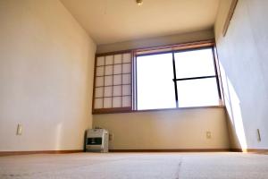 una stanza vuota con una grande finestra in un edificio di FWA Guest House a Fujinomiya