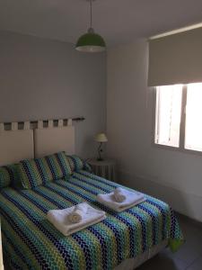 a bedroom with a bed with two towels on it at Los Cerros 2 in Chilecito