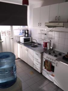 a kitchen with white cabinets and a stove top oven at Los Cerros 2 in Chilecito