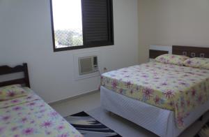 1 dormitorio con 2 camas y ventana en Hotel Harmonia, en Araras